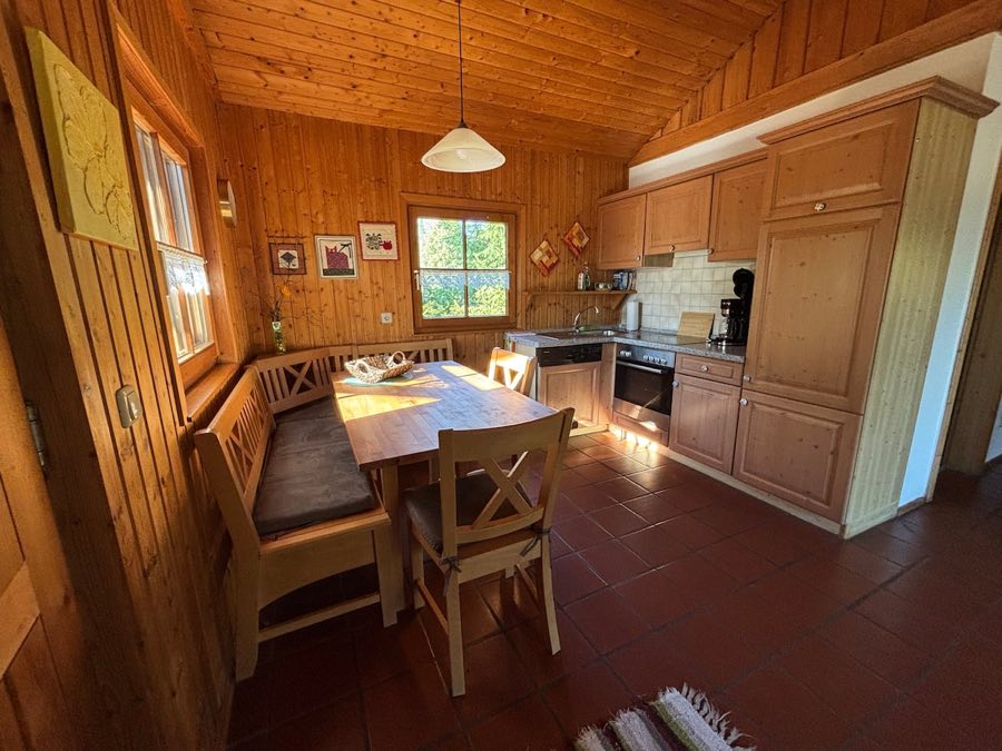 Küche aus hellem Holz mit Eckbank, Esstisch, Herd und Backofen
